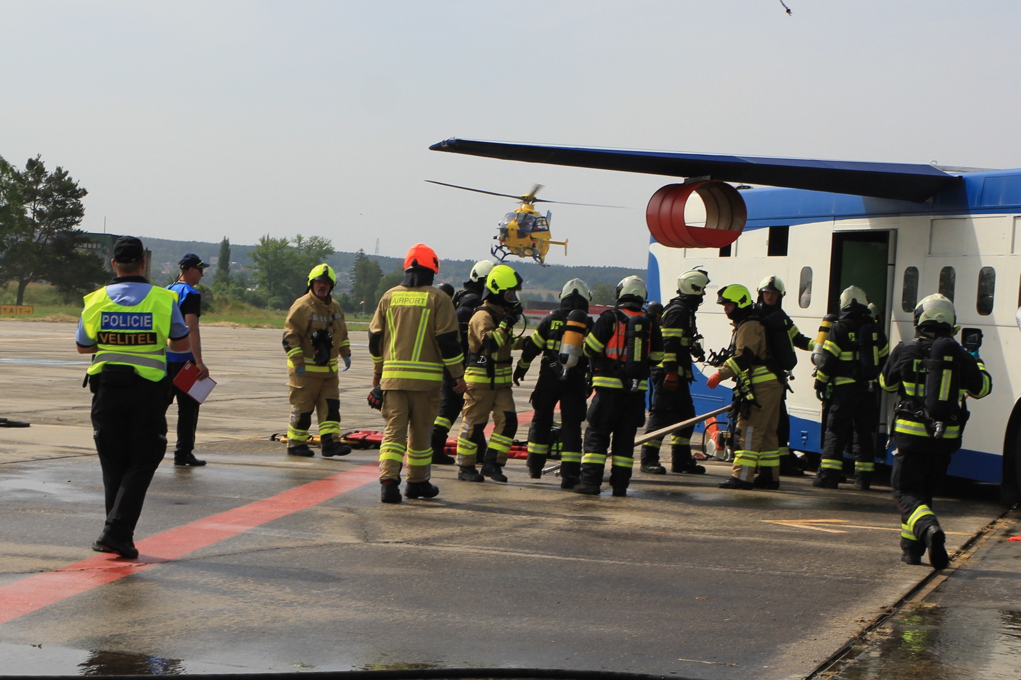 2_Letištní hasiči zahajují vyprošťovací a záchranné akce. V pozadí přistává vrtulník LZS..jpg (527 KB)